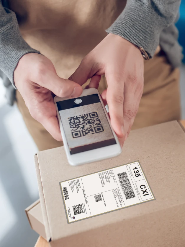 Image d'un homme qui scanne un QR Code sur l'étiquette d'un colis