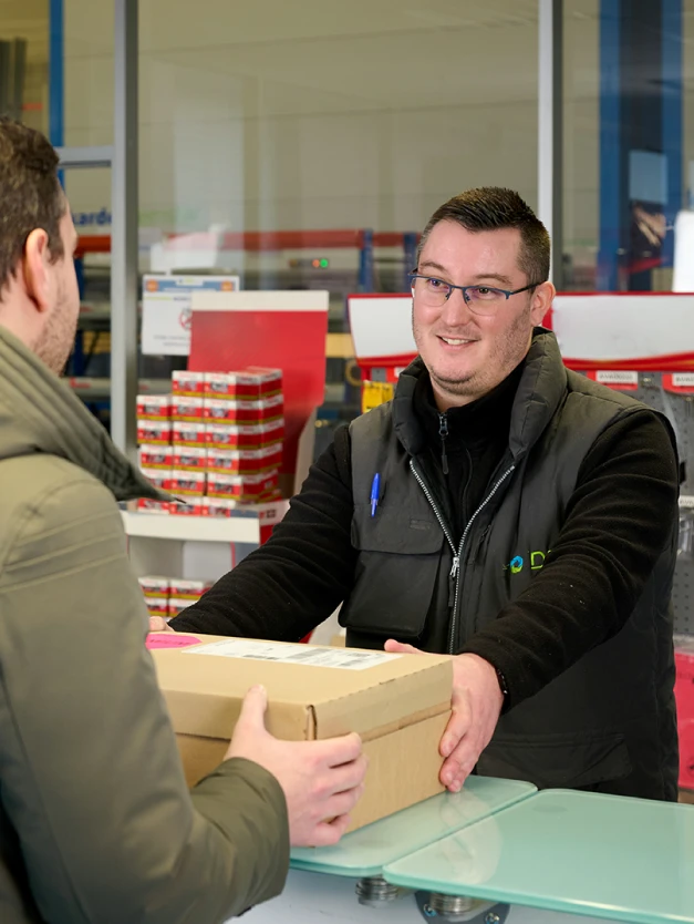 Image d'un homme qui réception un colis au comptoir de son agence